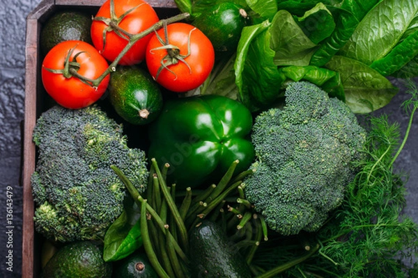 Fototapeta Food background of green vegetables broccoli romaine lettuce celery pepper zucchini on black table Healthy lifestyle Top view Copy space