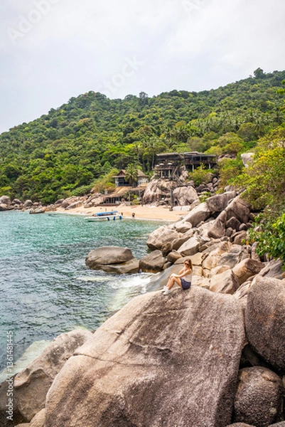 Obraz kobieta na widoku rajskiej plaży z wielkimi skałami
