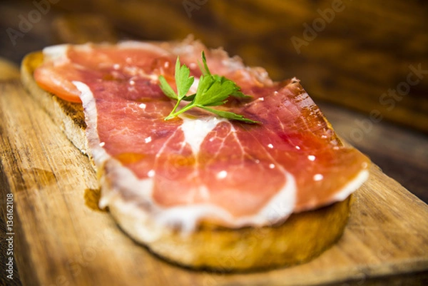 Fototapeta Bread toast with iberian cured pork ham and olive oil