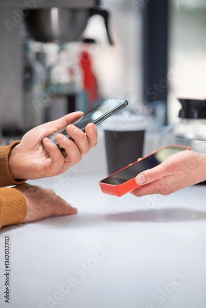 Fototapeta Close-up: a customer makes a purchase in a coffee shop, pays with a QR code. Scans the QR code with a smartphone in the bank's application.