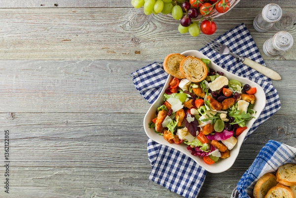 Obraz Traditional spring Italian salad with breaded chicken, camembert cheese, grapes and nuts. Served with croutons.