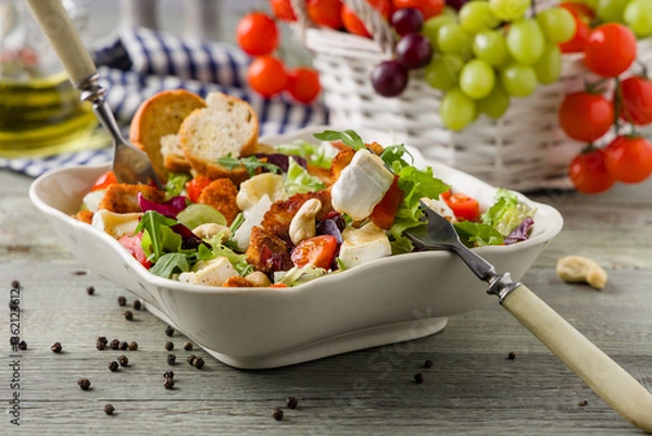 Obraz Traditional spring Italian salad with breaded chicken, camembert cheese, grapes and nuts. Served with croutons.