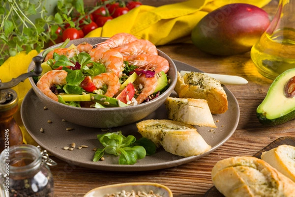 Obraz Spring salad with shrimp, mango and avocado. Served in a bowl, with croutons, sprinkled with roasted sunflower seeds.