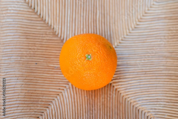 Obraz Vibrant orange resting on a textured surface brings warmth to the setting