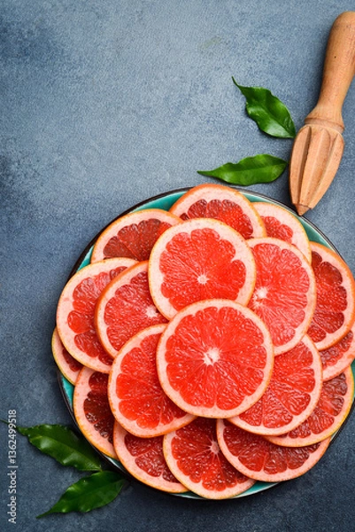 Fototapeta Cut grapefruit slices on a plate ready to eat. Close up macro, top view.