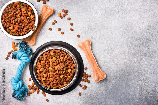 Fototapeta Pet bowl with dry food on a gray textured background. Studio photo.