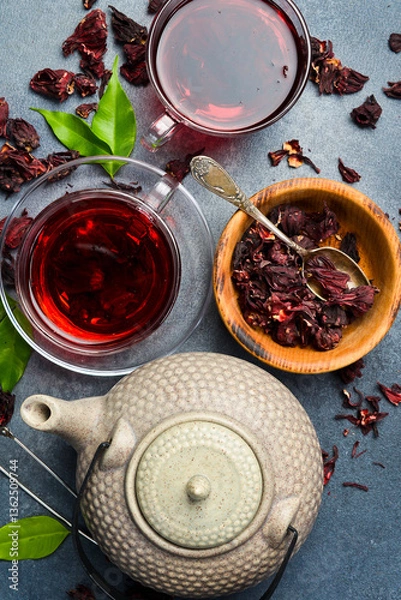 Fototapeta Cup of vitamin hibiscus tea with teapot on table. On stone background. Tea background.