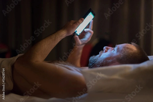 Fototapeta Texting in a bed