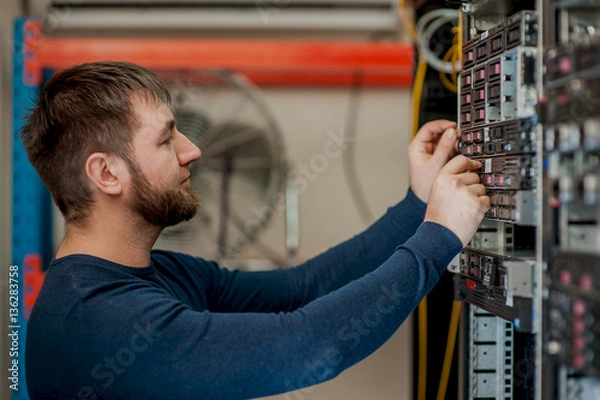 Obraz network engineer working in server room