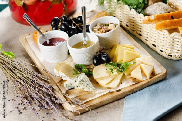 Obraz assorted cheeses with honey, jam, nuts and grapes
