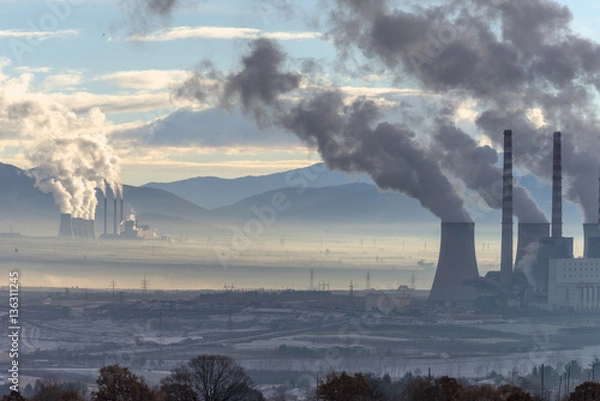 Fototapeta Power plant with smoking chimneys. Mountains in the background..