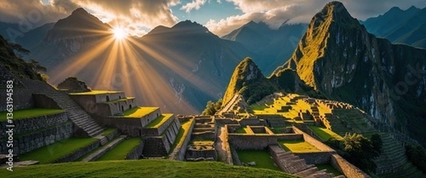 Fototapeta Sunrise casts golden rays over the historic site of Machu Picchu, highlighting the intricate stone ruins and surrounding lush hills. Visitors marvel at the stunning landscape