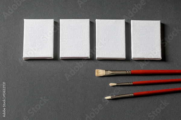 Obraz start something new with empty canvas and brushes