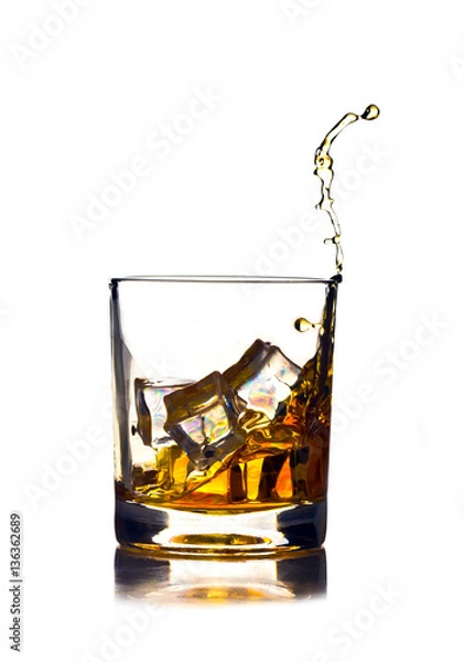 Fototapeta glass of whiskey with ice and drops splash on a white background
