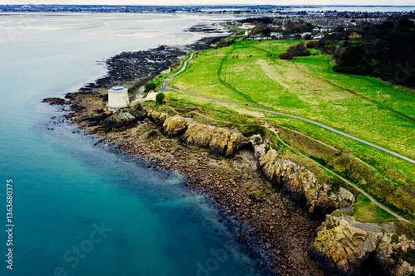 Obraz Aerial Drone View of the Irish Rocky Coastline With Martello Tower in Howth – Cliffs, Blue Sea and Lush Greenery
