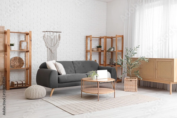 Fototapeta Beautiful interior of living room with black sofa, chest of drawers, coffee table and olive tree