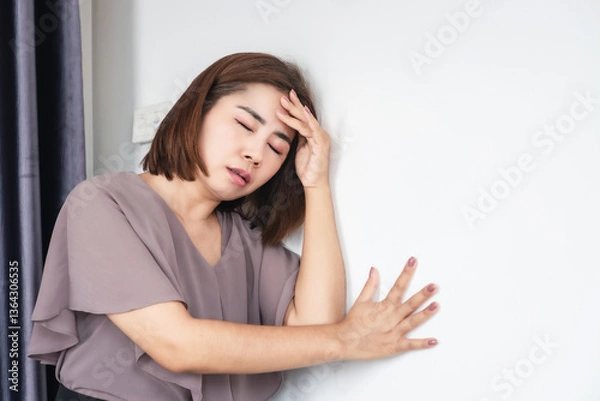 Obraz asian woman feeling weak and dizzy due to anemia, experiencing sudden vertigo, headache, and loss of balance, possibly caused by low iron levels or an ischemic stroke , heat stroke