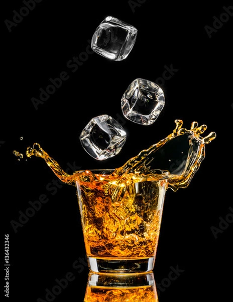 Obraz Szklanka whisky z plusk na czarnym tle