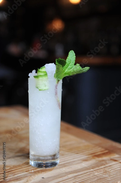 Obraz Refreshing cocktail with mint garnish at a bar