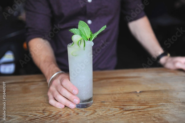 Obraz Refreshing cocktail with mint garnish at a bar