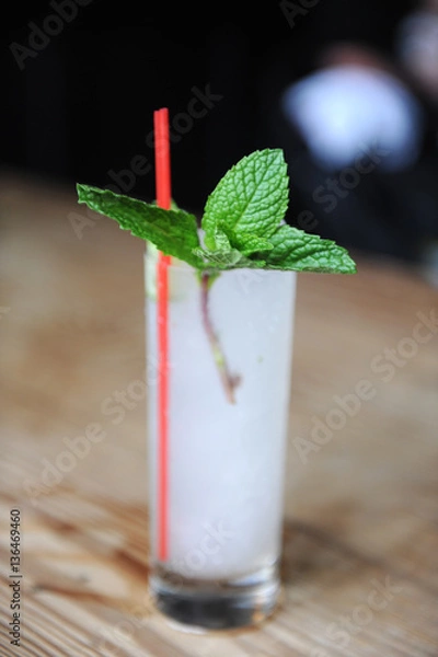 Obraz Refreshing cocktail with mint garnish at a bar