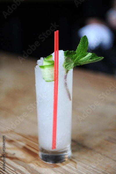 Obraz Refreshing cocktail with mint garnish at a bar