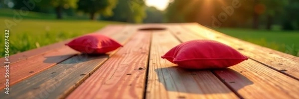 Fototapeta Low angle view of corn hole game with red bean bags on wooden platform, red bags, casual games
