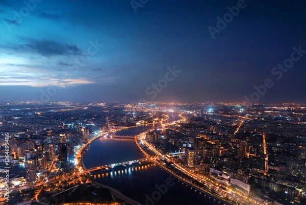 Fototapeta Cityscape from the height of an airplane flight at night. Illuminated streets, buildings, bridges, embankment