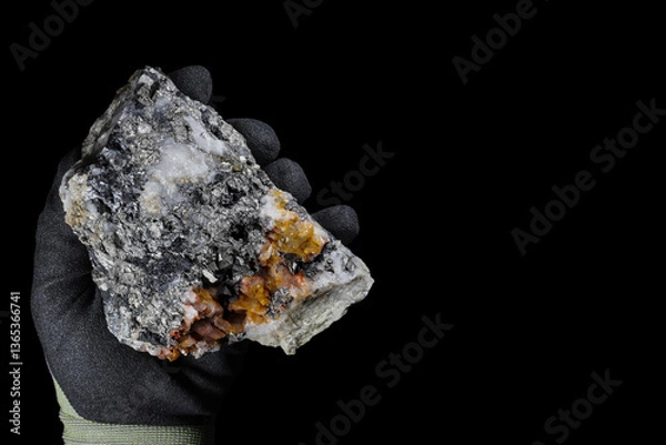 Fototapeta Arsenopyrite (FeAsS), iron arsenic sulfide mineral. Metallic, steel grey, silver color. Found in association with gold, potential source for toxic arsenic. Held in hand with protective glove. Black