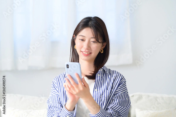 Obraz スマホを持って微笑む日本人女性