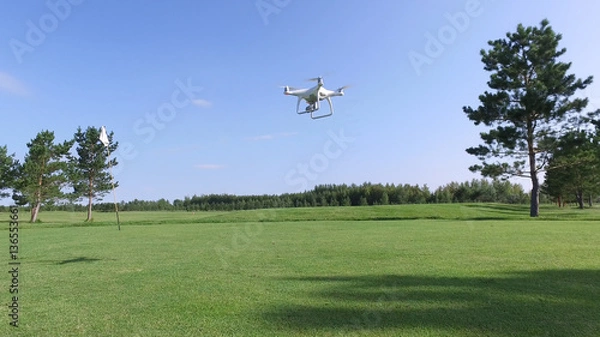 Obraz Drone with camera flies up over the golf course.