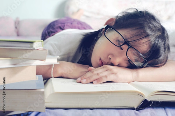 Obraz asian child sleeping while reading in the bed.