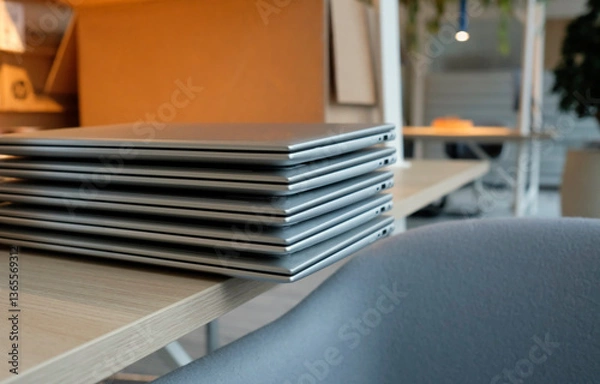 Fototapeta Stack of laptops on a table in a co-working space