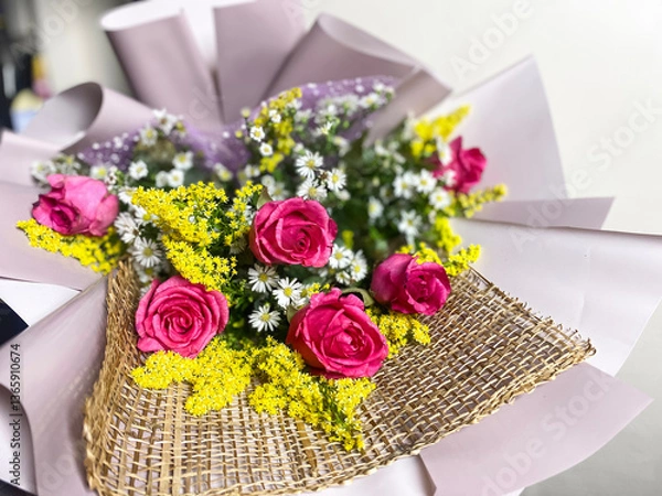 Fototapeta delicate bouquet with roses in purple paper complemented by small yellow flowers