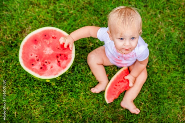 Fototapeta Little one enjoying summer treat with big bite of watermelon