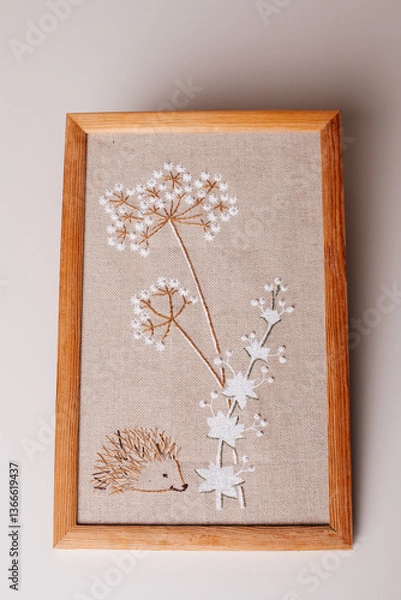 Obraz A handmade embroidery artwork featuring delicate white flowers, beautifully framed in wood for a cozy home decor touch.