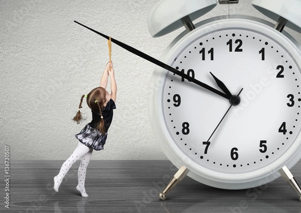 Fototapeta Little child pulling hand clock, time management concept