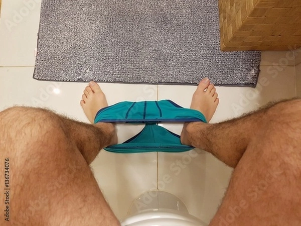 Fototapeta Up point of view of a man sitting in the toilet