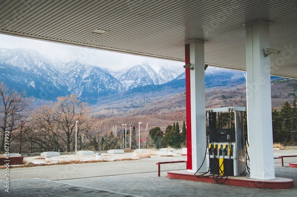Fototapeta Magnificent views of the car refueling with views of the beautiful mountains with snow