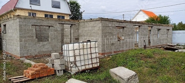 Fototapeta unfinished block walls standing on a brick foundation