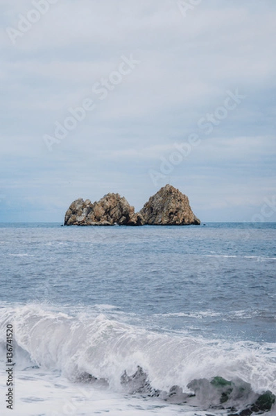 Fototapeta Magnificent views over the cliff into the sea. Falling wave amid the rocks.