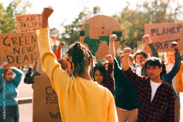 Fototapeta Group of activists protesting for climate action, raising fists and holding signs for environmental justice