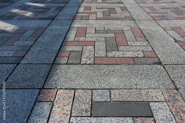 Fototapeta Texture of square paving tile. Pattern of gray, red, orange and beige sidewalk tiles in the street. Concrete pavers close up background.