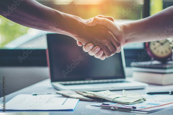 Fototapeta business partners handshaking after business success negotiation at meeting room