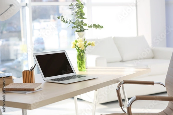 Fototapeta Workplace with laptop on table in modern room