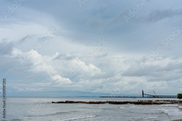 Fototapeta Seascape of a coastline with a dock at a port for coal transport ships in the Colombian Caribbean.