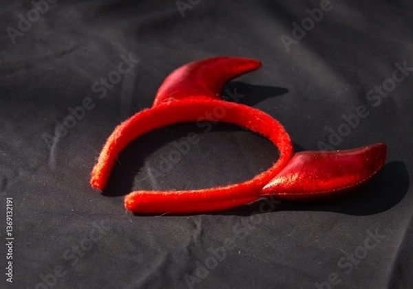 Obraz red devil horn headband against black background