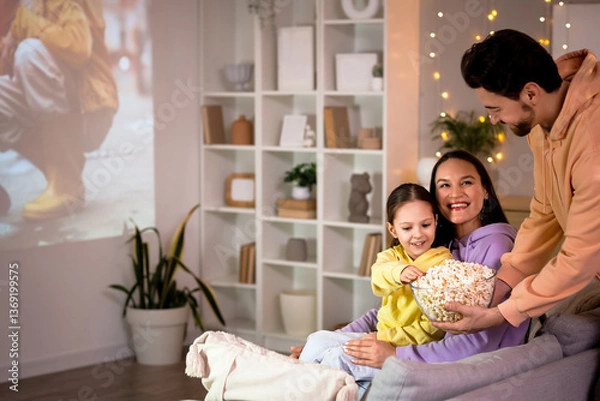 Fototapeta Family eating popcorn while watching movie at home