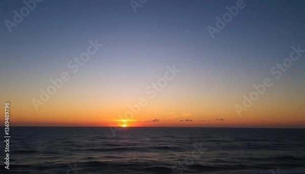 Fototapeta Orange sunset paints the evening sea, reflecting light on gentle waves