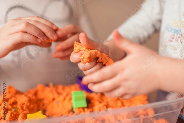 Fototapeta hands of a kid playing with magic sand